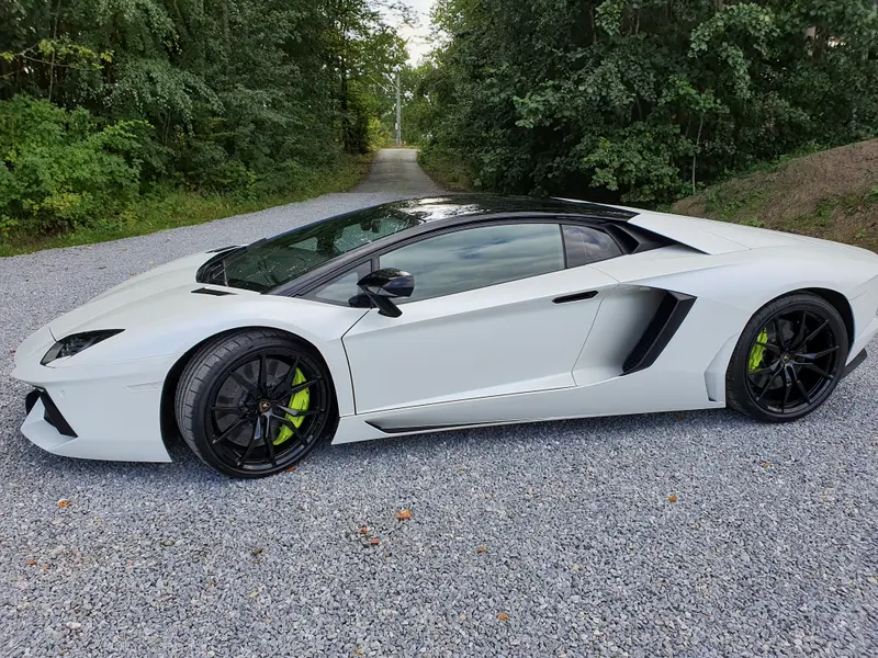 Weißer Lamborghini Aventador mit schwarz abgesetztem Dach und getönten Scheiben