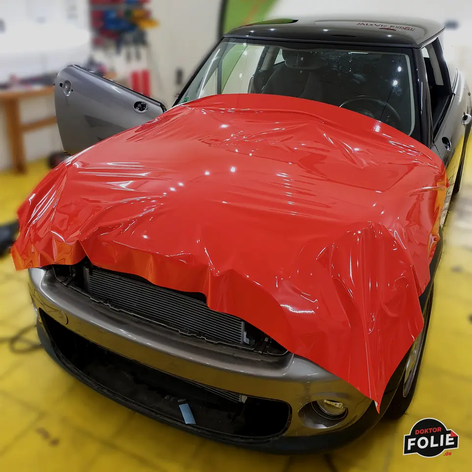 Folie wird auf einer Motorhaube verarbeitet – Handarbeit bei Doktor Folie