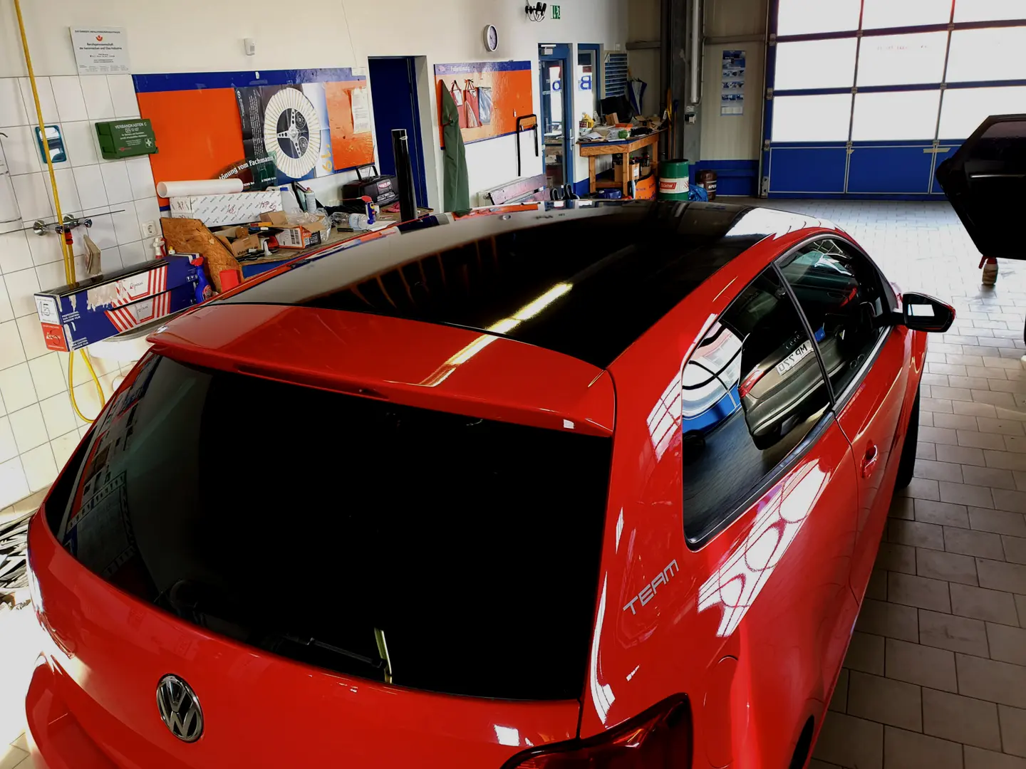 Roter VW mit getönten hinteren Scheiben